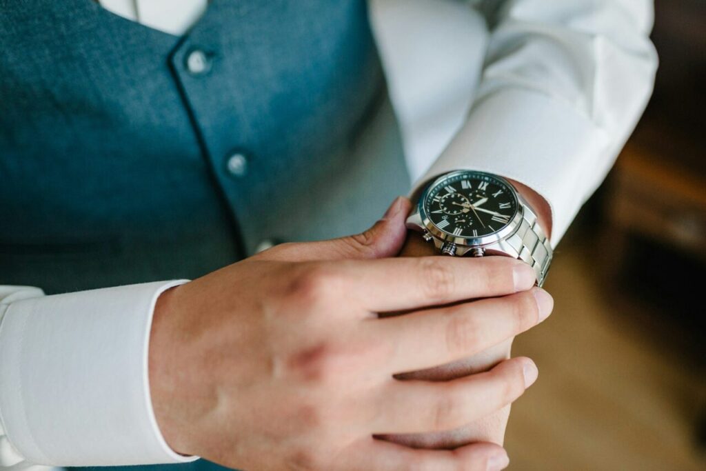 A man in a shirt adjusts the watch on his arm. Close up of businessman using watch.